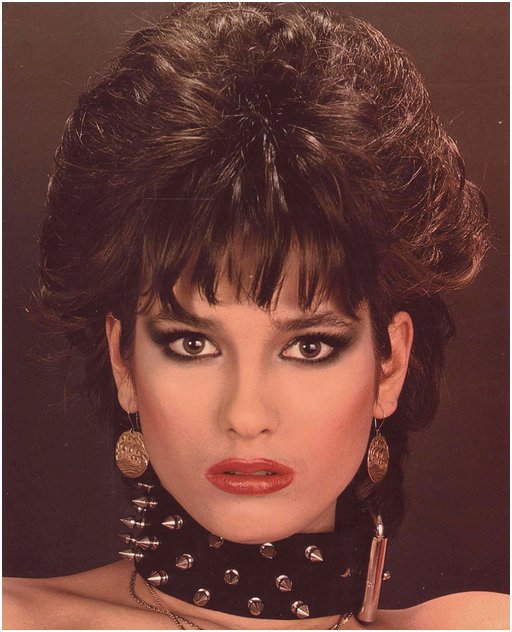 brunette with big hair and a spiked leather collar